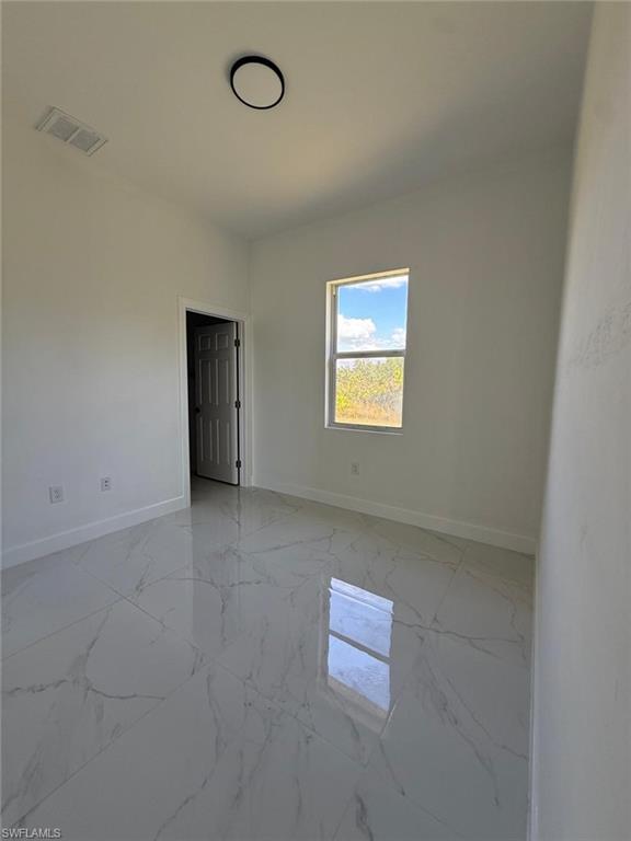 Spare room with light marble finish floors and baseboards