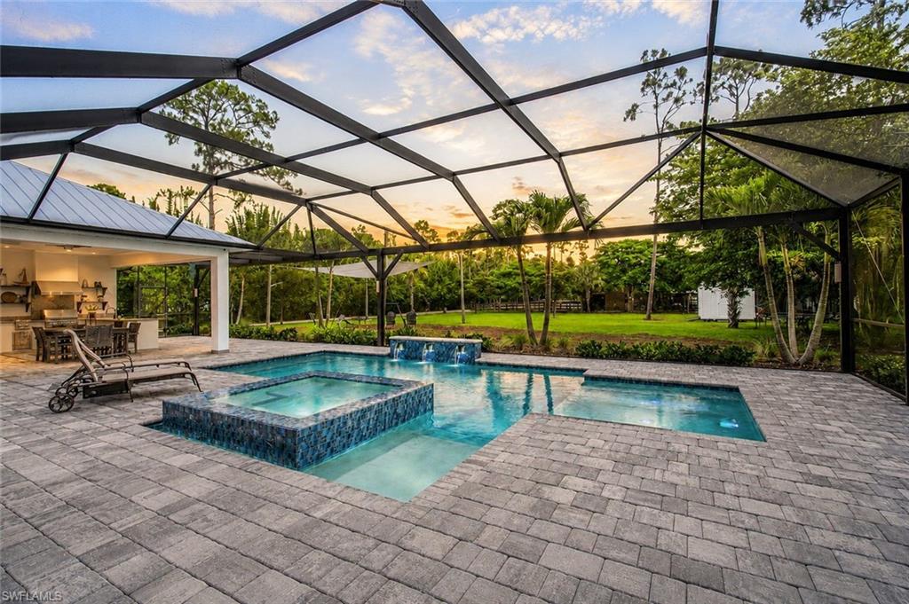 1450 ft.² custom paver screened lanai entertaining - including a expansive Summer kitchen, designer saltwater pool & spa and 3 shaded lounge and dining areas.