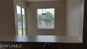 Expansive water feature visible through large sliding glass doors and an additional window with blinds