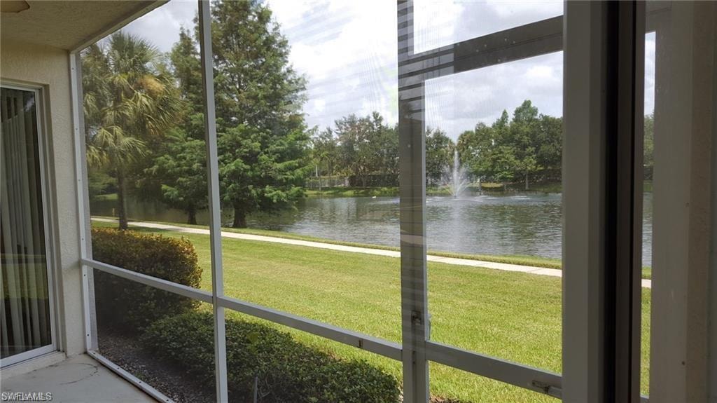 Screened patio offering direct access to a grassy area, mature landscaping, and a water feature with a fountain
