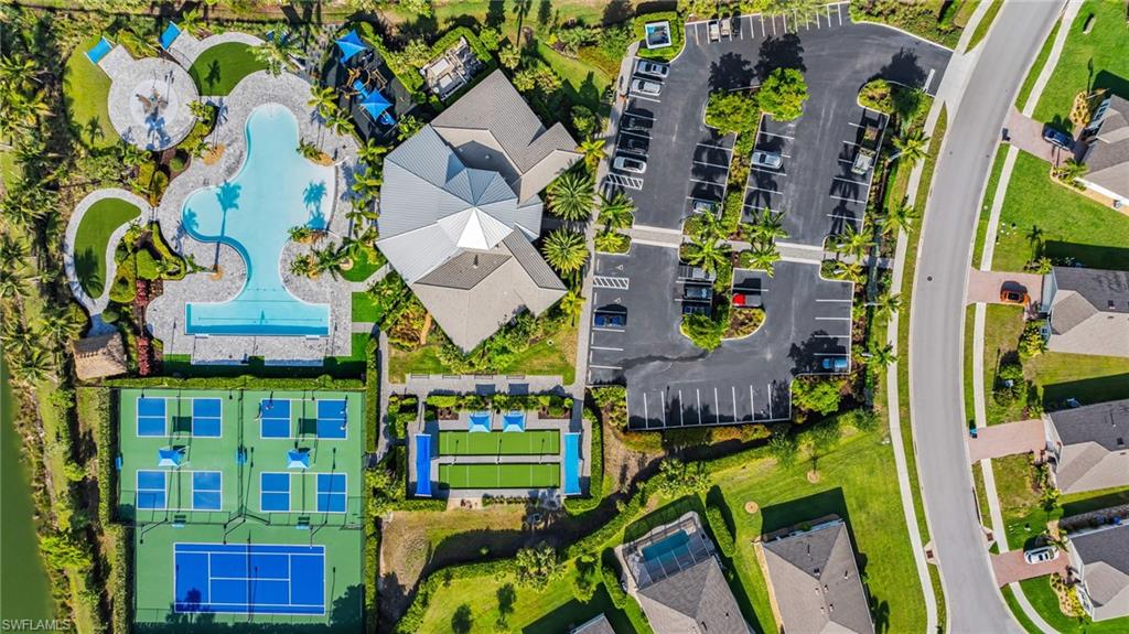 Resort-style amenities featuring multiple swimming pools, extensive patio areas, a large clubhouse building, pickleball courts, and a tennis court