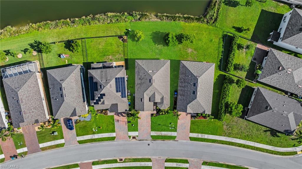 Aerial perspective showcasing a residential community with paved driveways and well-maintained lawns