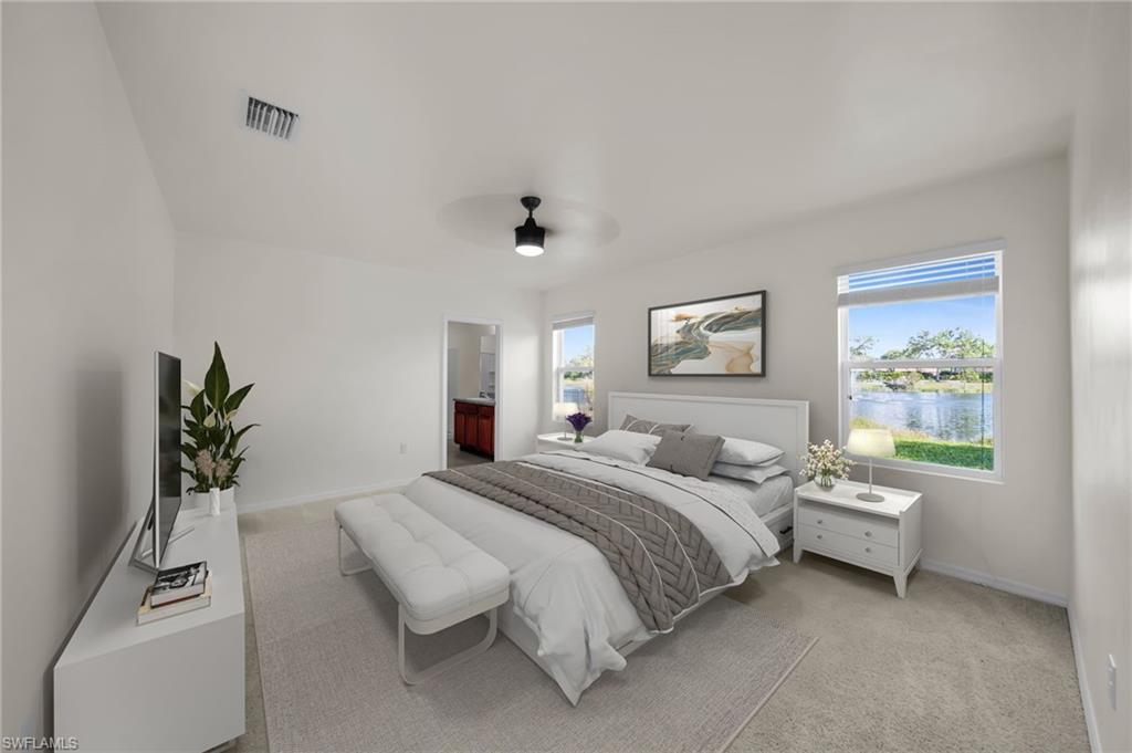 Carpeted bedroom featuring multiple windows, a ceiling fan with integrated lighting, and white baseboards.    Virtually Staged