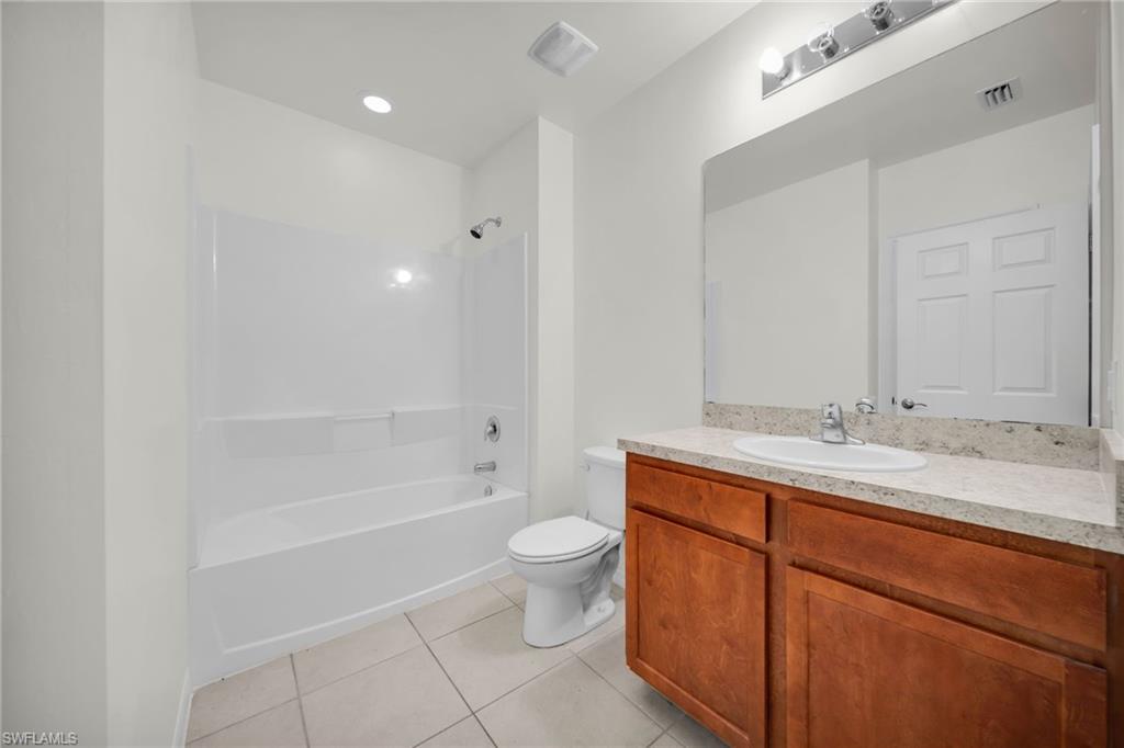 Bathroom featuring a spacious vanity with wood cabinetry, a light-toned countertop, and an integrated sink