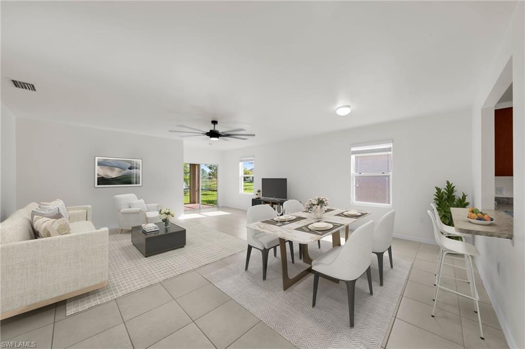 Spacious open-concept living and dining area featuring light-toned tile flooring, a contemporary ceiling fan, and ample natural light from multiple windows and a glass door.    Virtually Staged