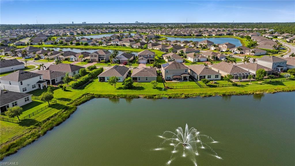 Waterfront community featuring single-family homes, manicured lawns, and mature landscaping