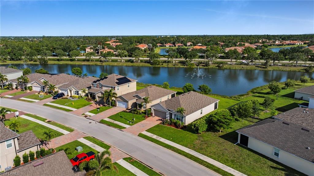 Expansive residential neighborhood featuring a central street, landscaped lawns, and mature trees