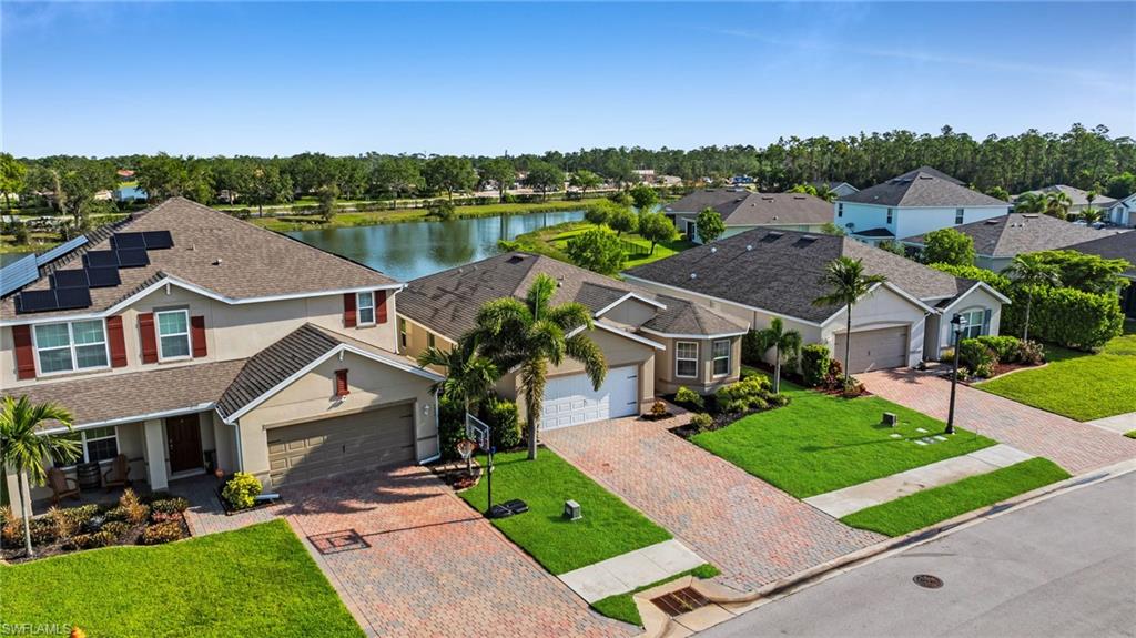 Two-story stucco residence with solar panels and a paver driveway