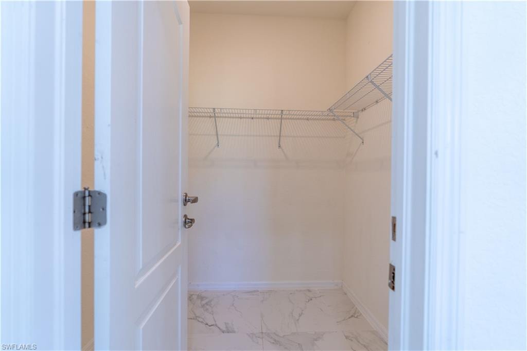 Walk-in closet with wire shelving system and white-finish door