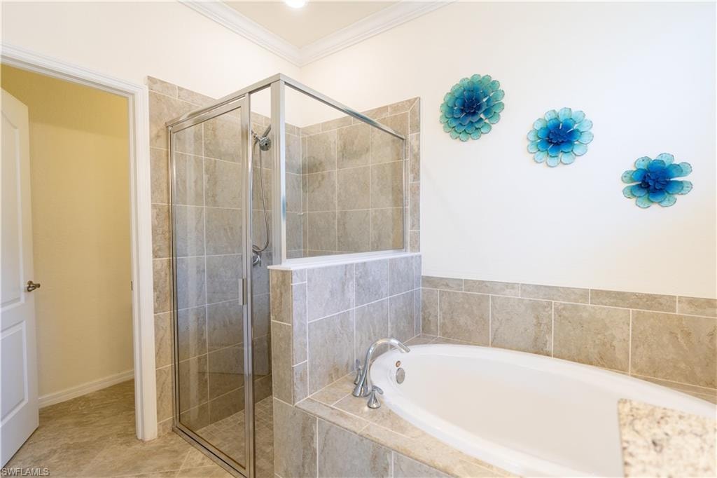 Expansive bathroom featuring a glass-enclosed shower, a large soaking tub with a surrounding tile deck, and a tiled floor
