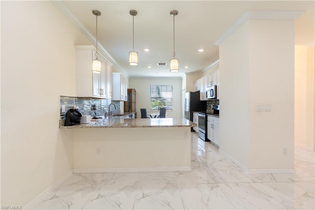 Contemporary kitchen featuring white cabinetry, a granite-finish countertop, and a mosaic tile backsplash