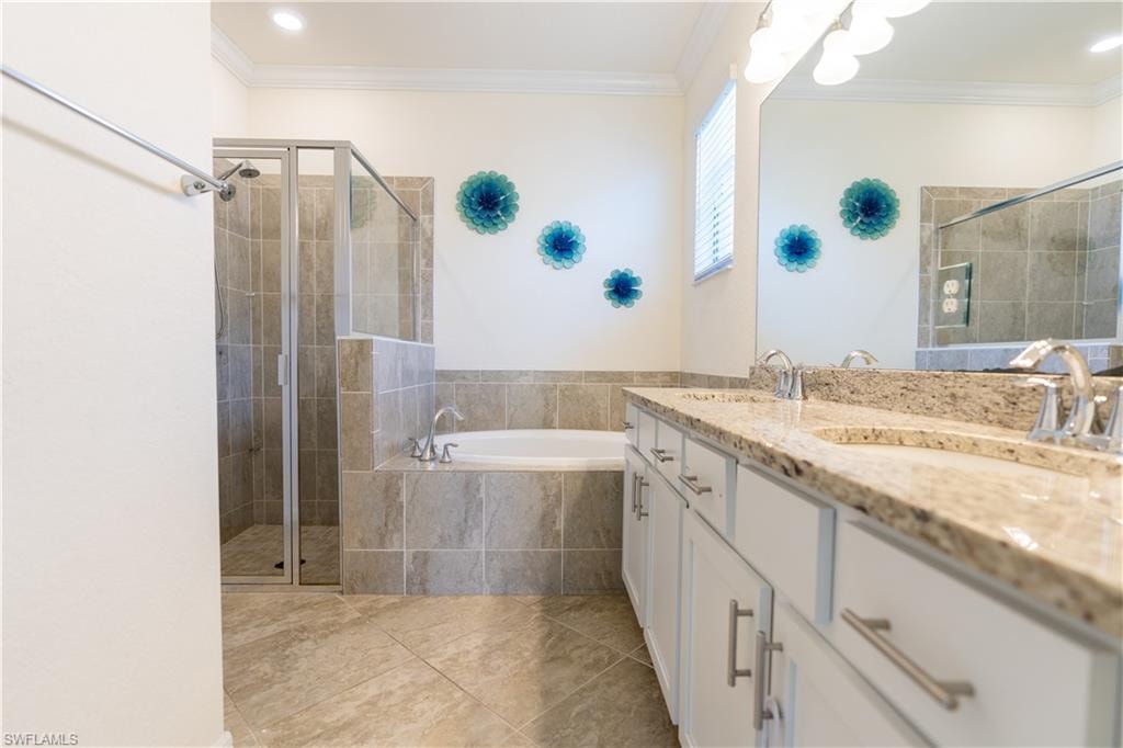 Spacious bathroom featuring a dual vanity with granite countertops, a built-in soaking tub, a separate glass-enclosed shower, and large format tile flooring