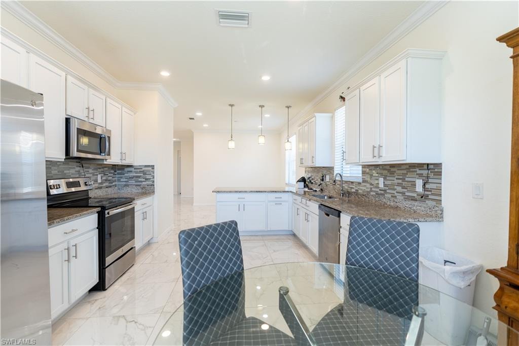 Modern kitchen with white cabinetry and stainless steel appliances