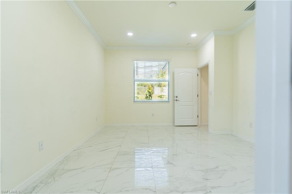Spacious room featuring large format tile flooring, crown molding, recessed lighting, and a window with blinds