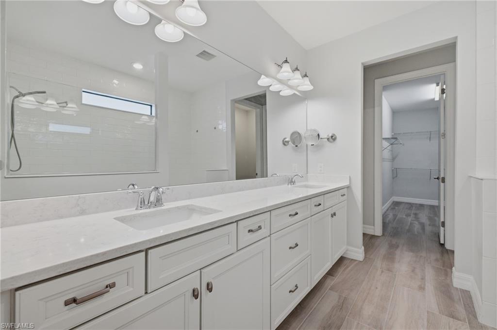 Double vanity with undermount sinks, chrome fixtures, and a spacious mirror