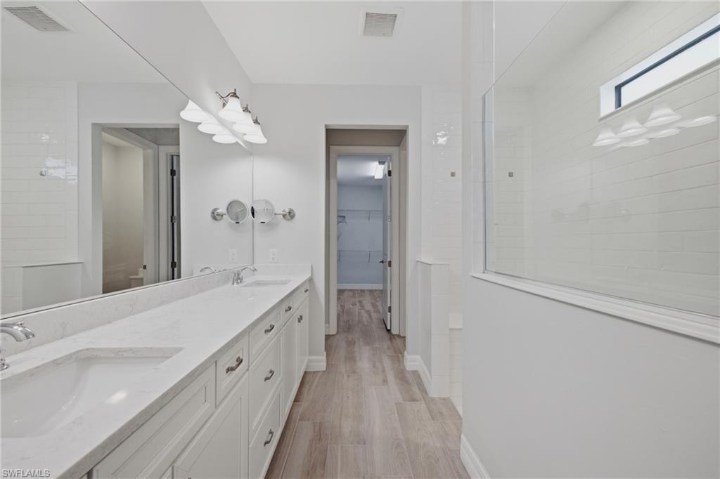 Bathroom featuring a dual vanity with undermount sinks and light-toned countertops