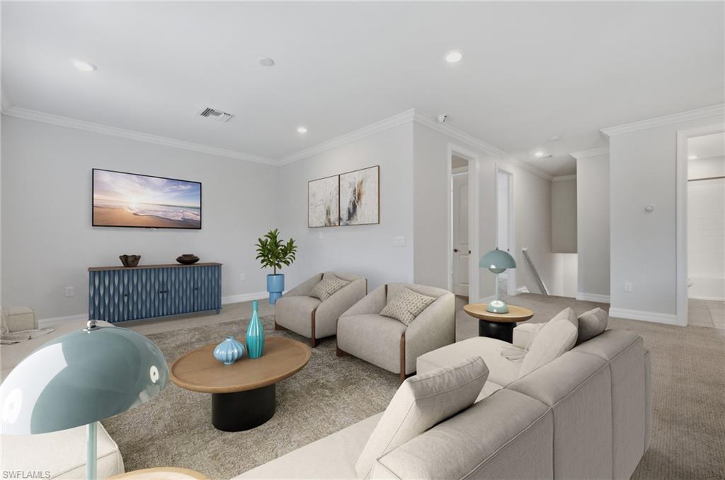 Spacious upper-level room featuring light gray walls, recessed lighting, crown molding, and carpeted flooring