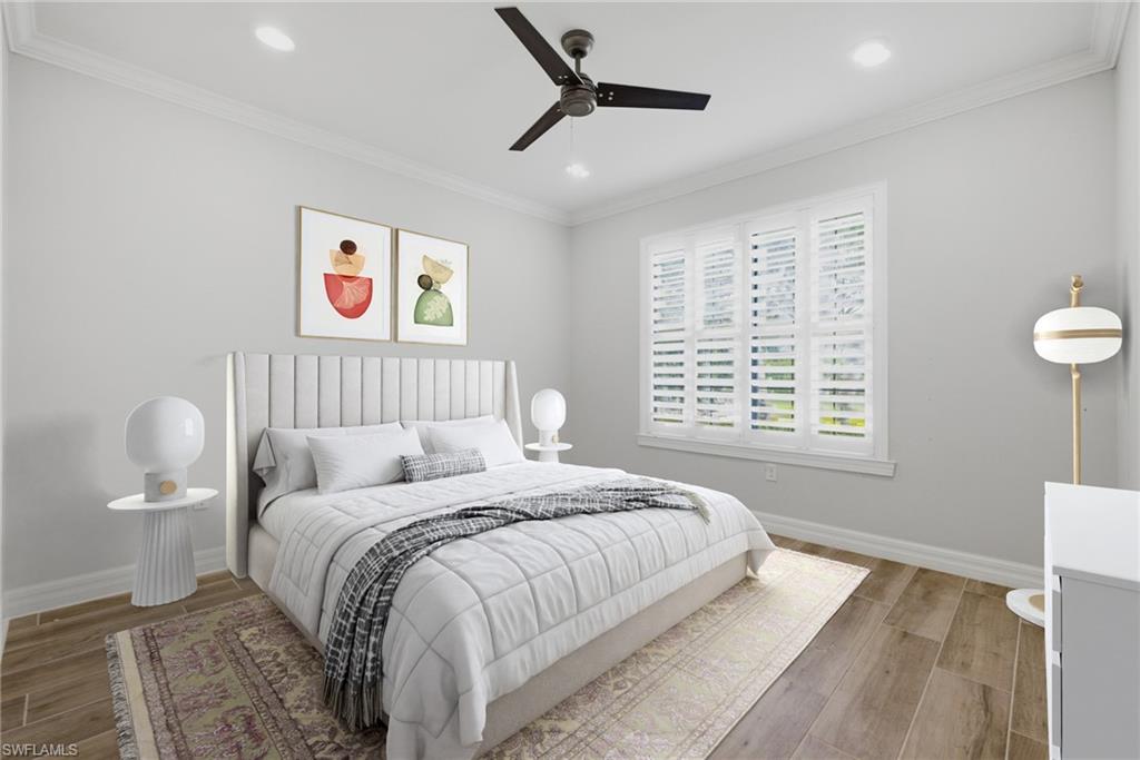 Spacious room featuring wood-finish flooring, crown molding, a ceiling fan, recessed lighting, and a large window with plantation shutters