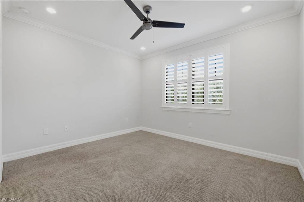 Carpeted room featuring a ceiling fan, recessed lighting, crown molding, and a window with plantation shutters
