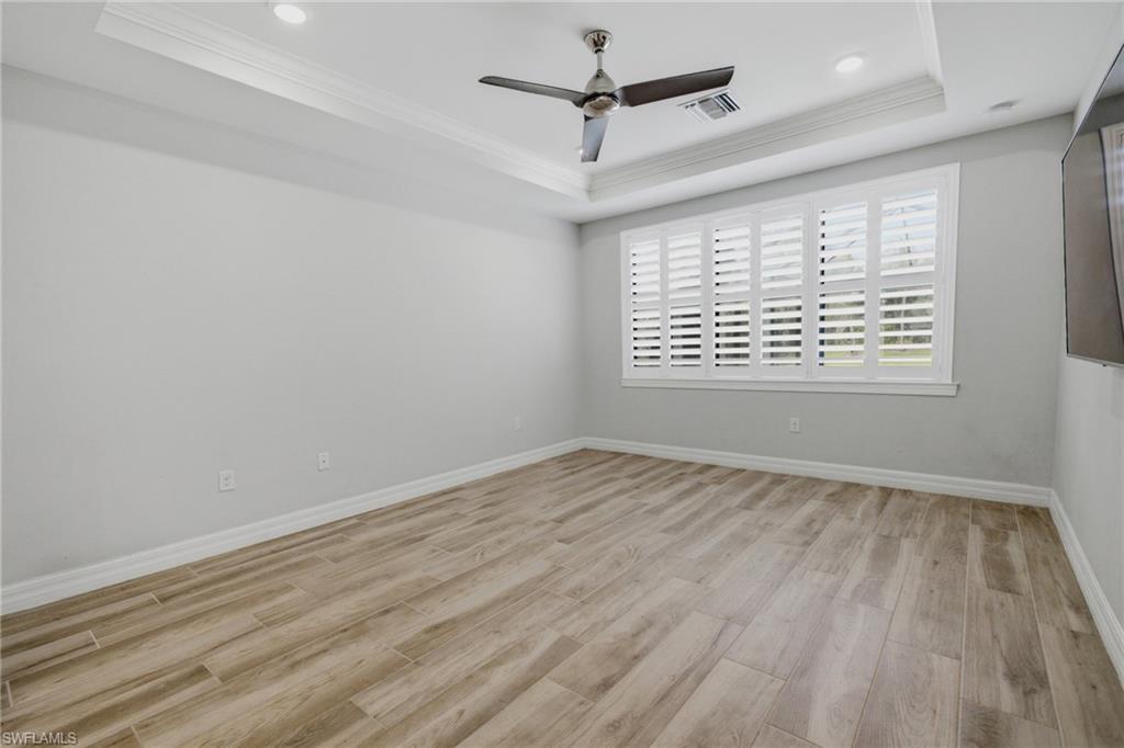 Recessed lighting illuminates a tray ceiling with crown molding