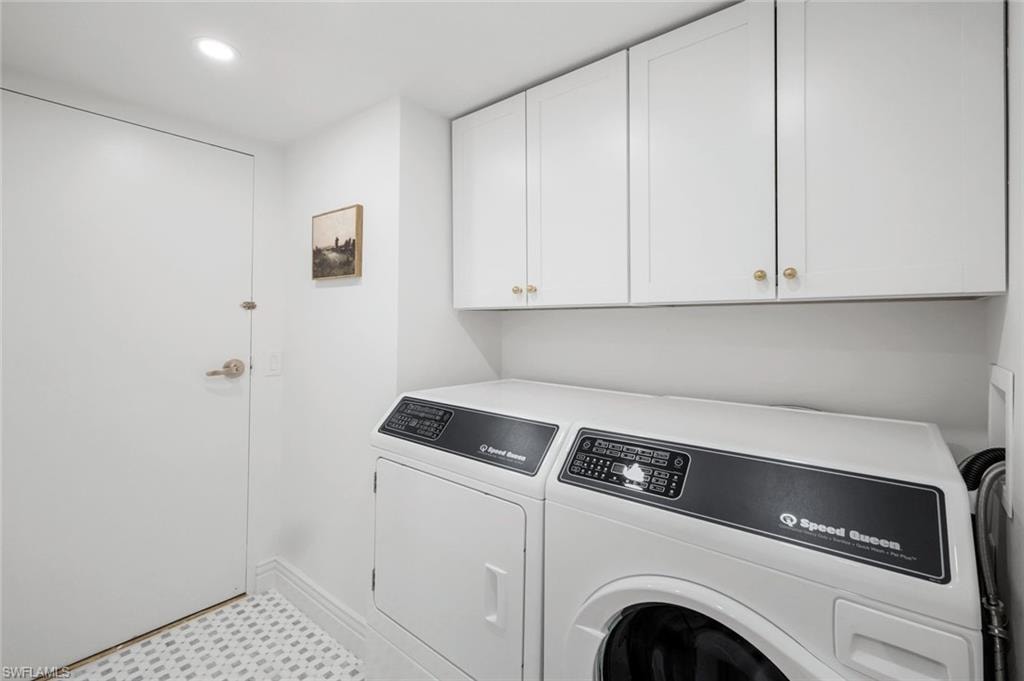 Laundry room with washing machine and clothes dryer, cabinet space, and recessed lighting