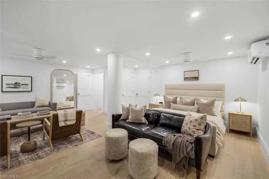 Bedroom featuring light wood finished floors, recessed lighting, and a wall unit AC