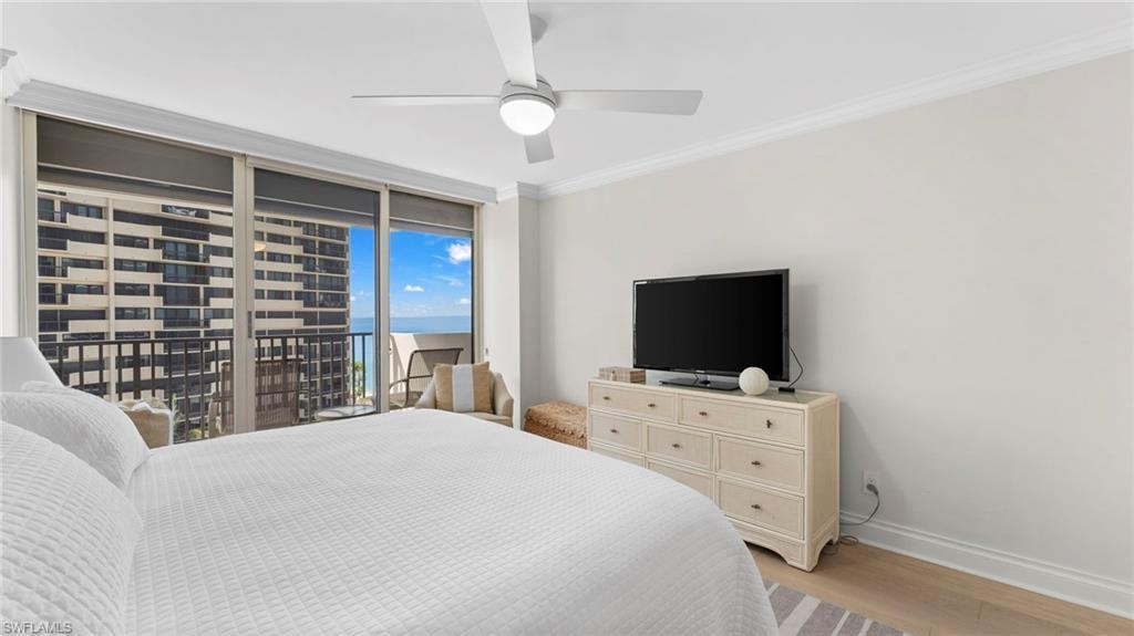 Bedroom featuring light wood-type flooring, ornamental molding, ceiling fan, and access to exterior
