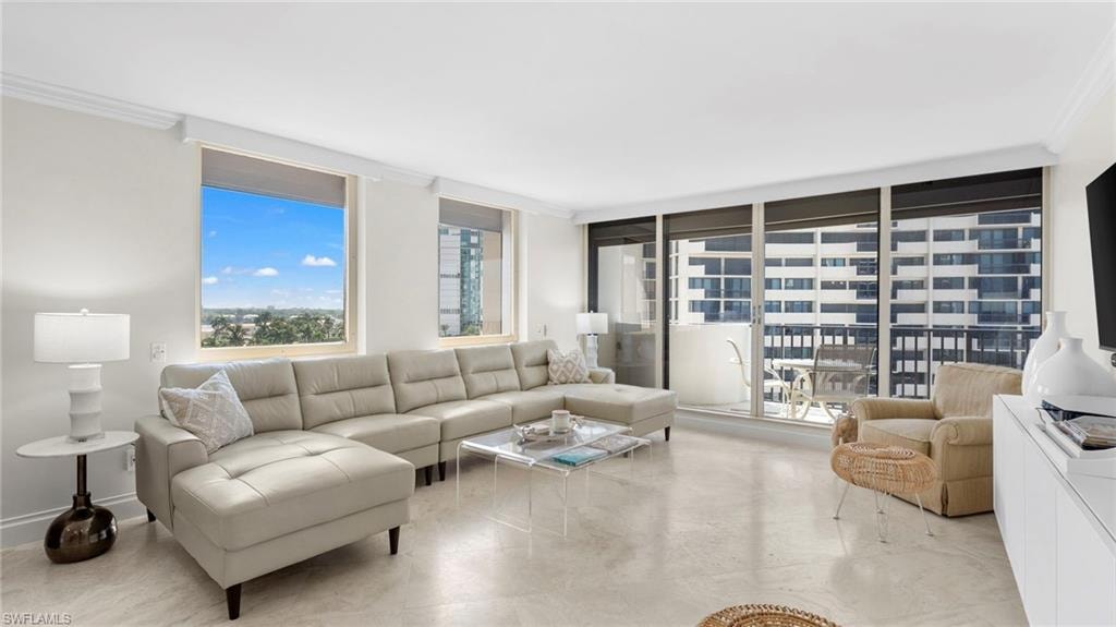Living room featuring floor to ceiling windows and crown molding