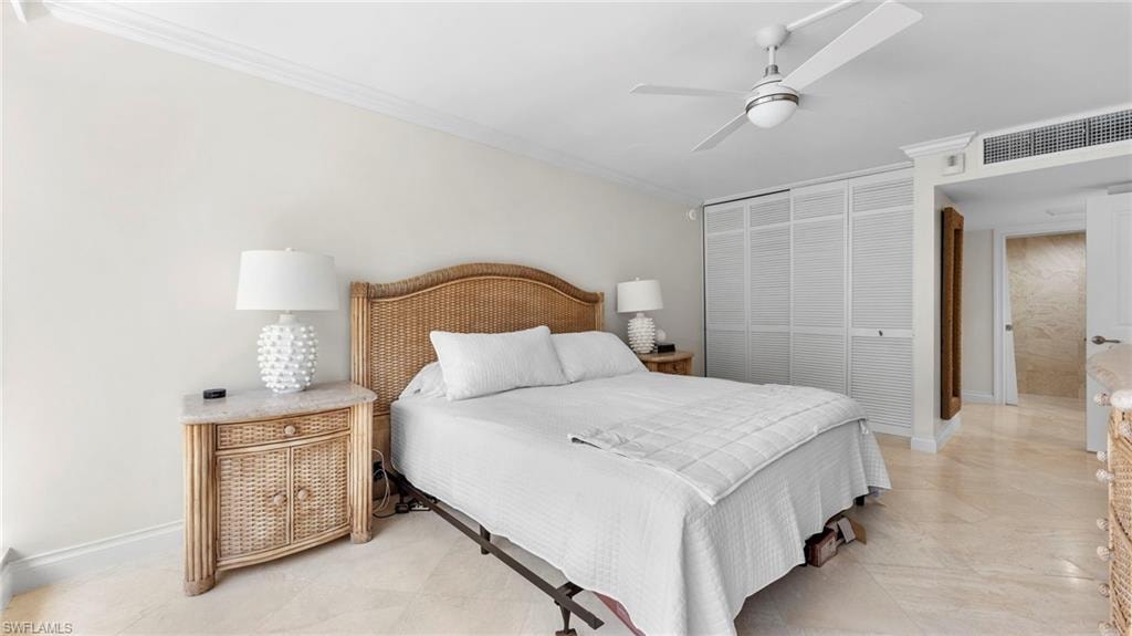 Bedroom with ceiling fan, light tile patterned flooring, a closet, and crown molding