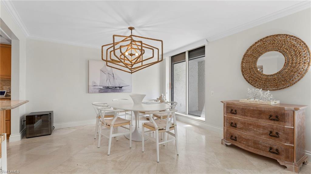 Dining space with ornamental molding and a notable chandelier