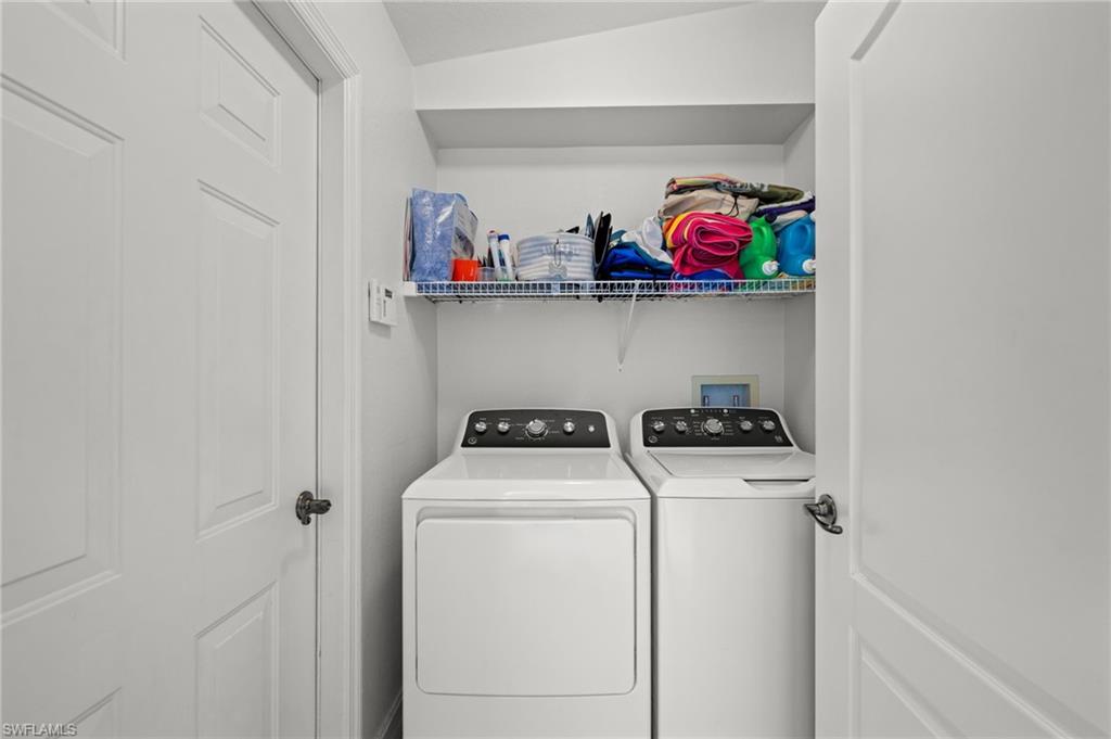 Dedicated laundry area featuring a built-in wire shelf and an upper storage shelf