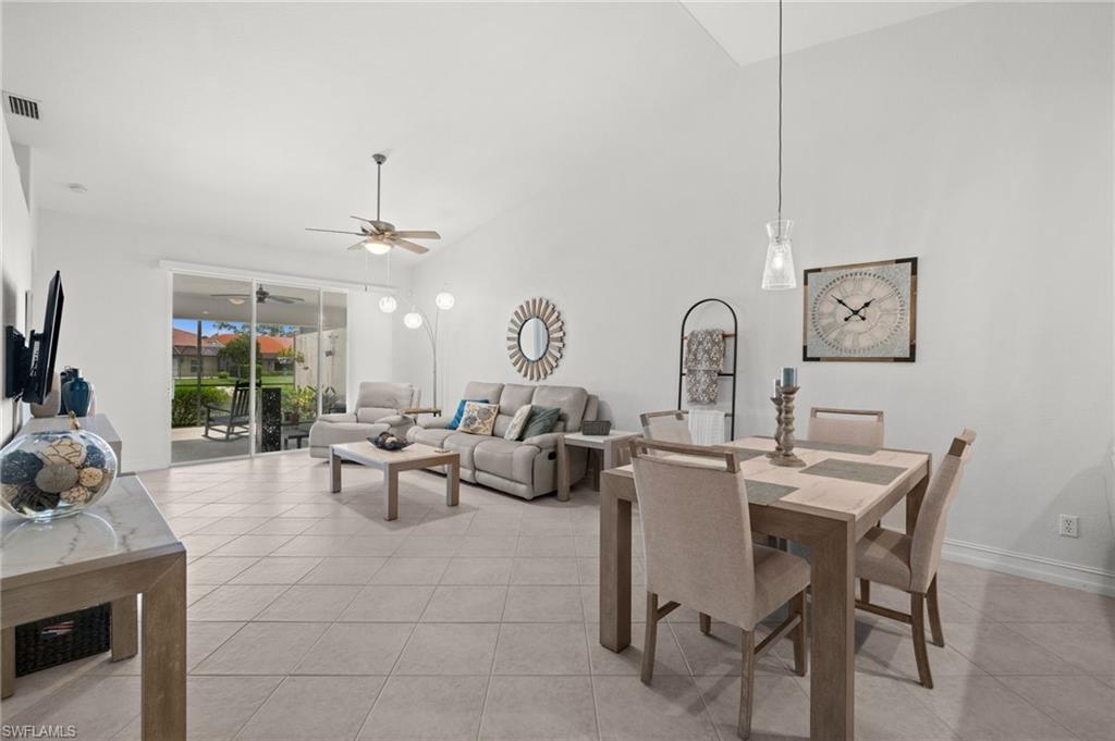 Vaulted ceilings extend over a combined living and dining area with tile flooring throughout