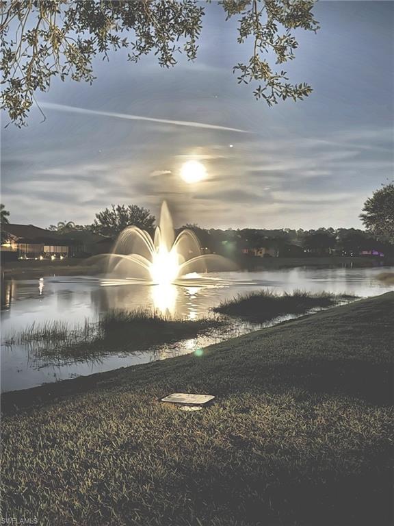 A lit fountain and a rising moon over the waterA lit fountain and a rising moon over the waterTwilight on the lake, the fountain glowing at its center
