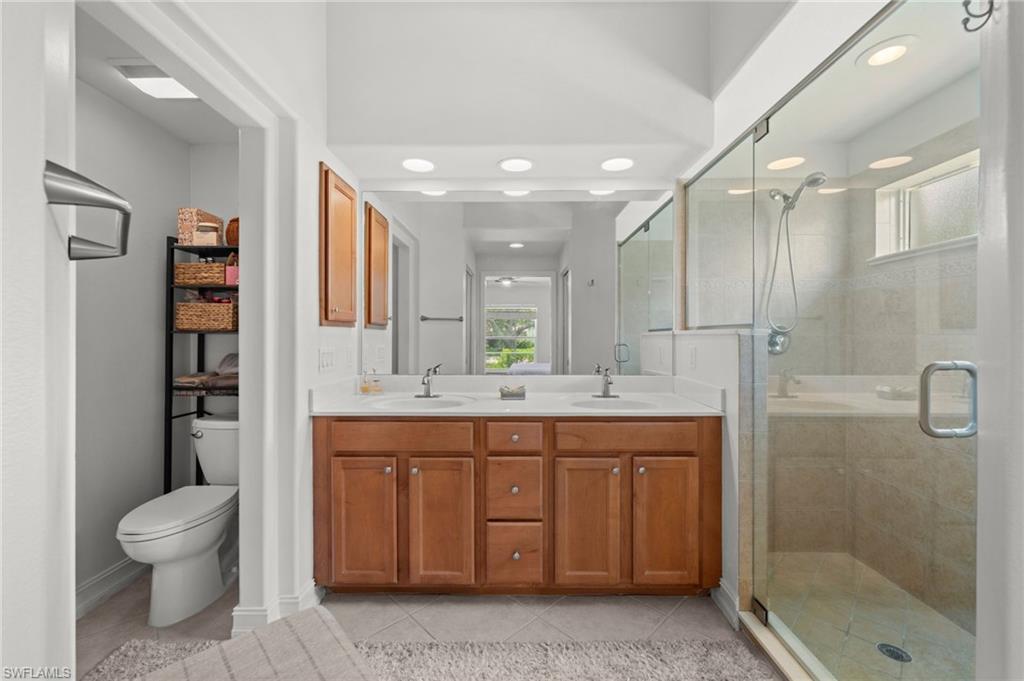 Dual vanity with wood-finish cabinetry and white countertops