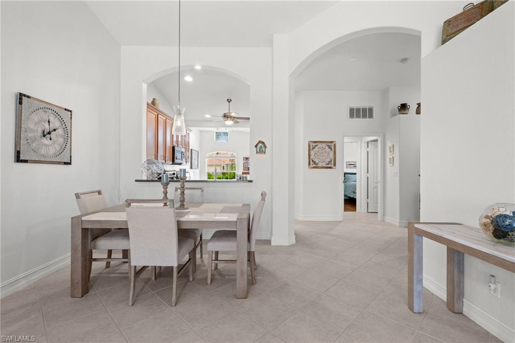 Dining area featuring neutral tile flooring and arched architectural details