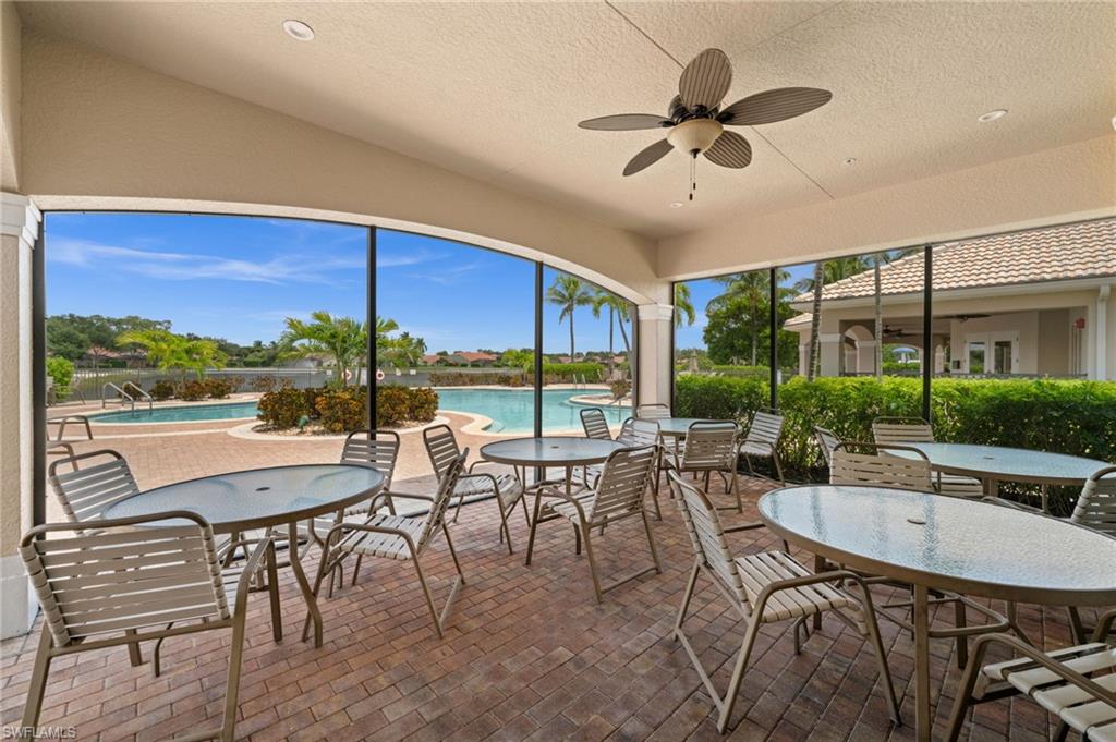Screened outdoor patio featuring brick pavers, a ceiling fan, recessed lighting, and ample seating overlooking the community pool