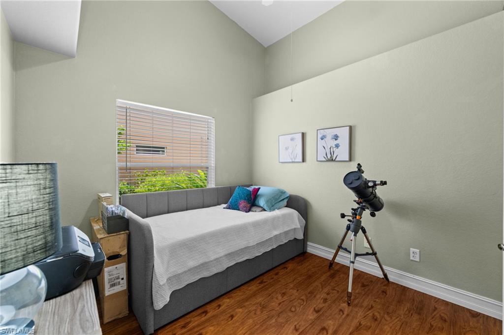 Interior room featuring a vaulted ceiling and wood-finish flooring