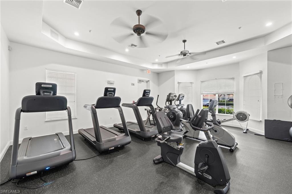 Dedicated fitness area featuring multiple exercise machines, recessed lighting, and dual ceiling fans
