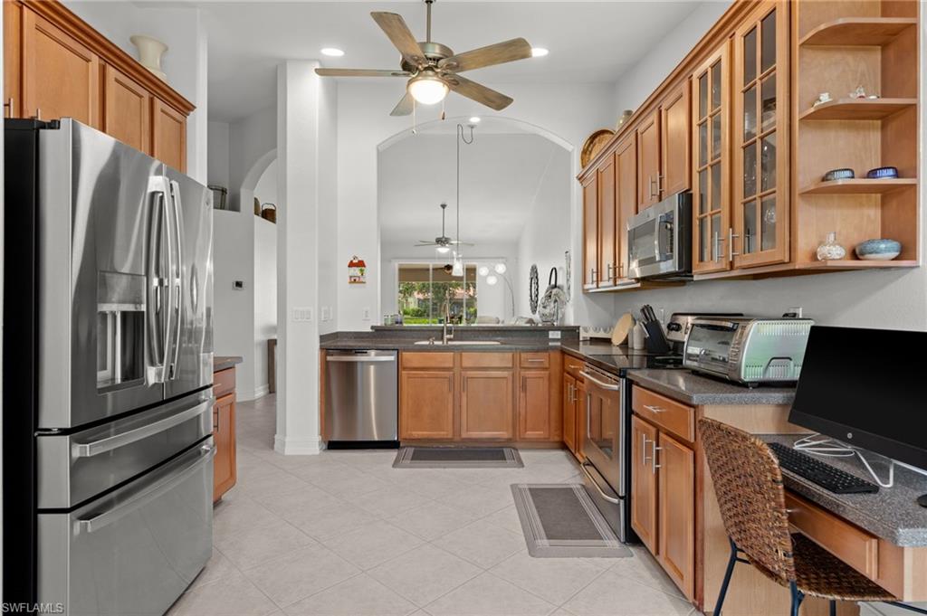 Kitchen with light wood cabinetry, stainless steel appliances, and a built-in desk area