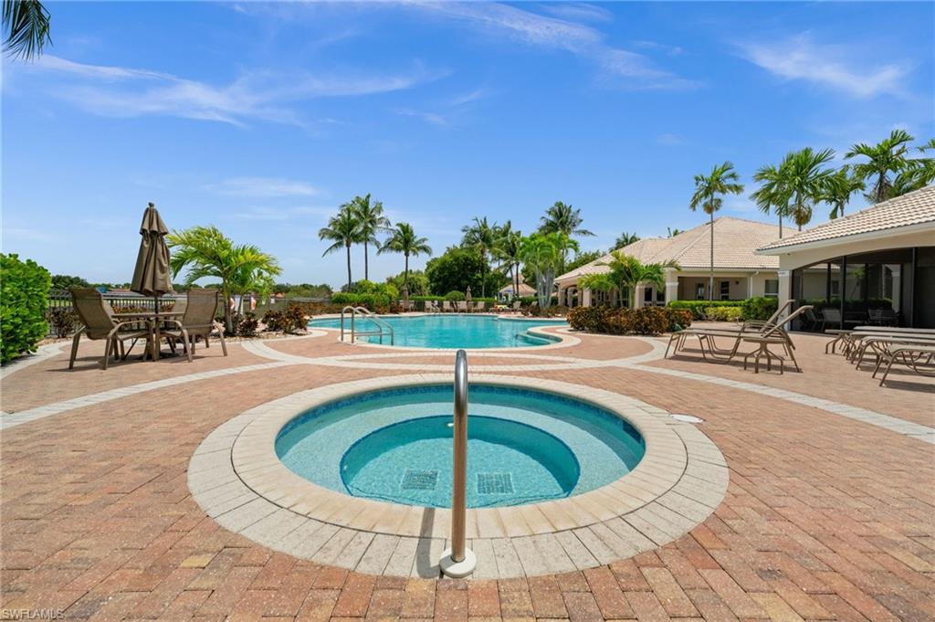 Outdoor spa with integrated steps, surrounded by a brick paver deck