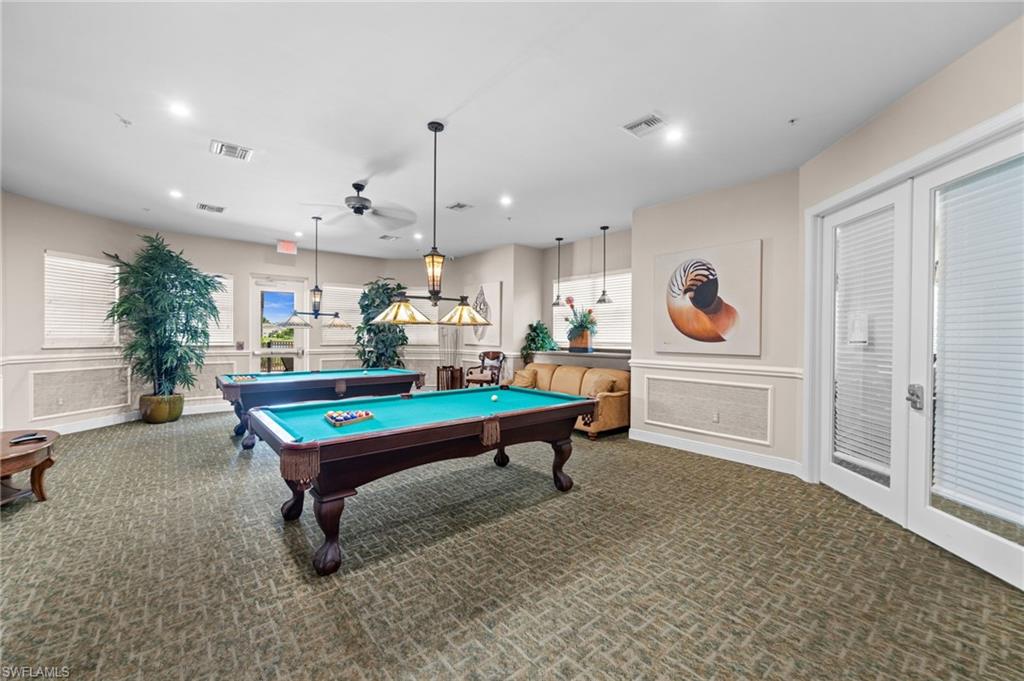 Spacious recreation room featuring two billiard tables, recessed lighting, ceiling fans, and textured carpet flooring