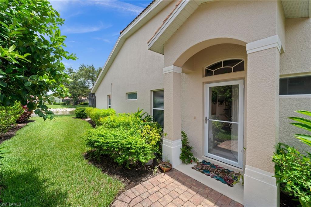 Entryway featuring an arched portico, transom window, and a glass storm door