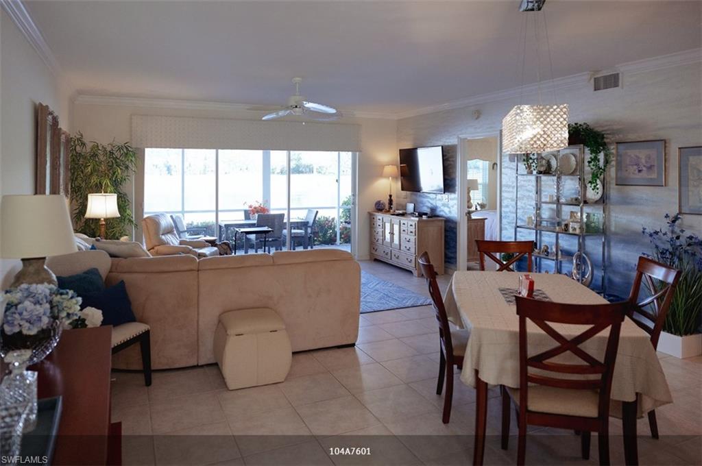 Tiled dining space with ornamental molding and ceiling fan