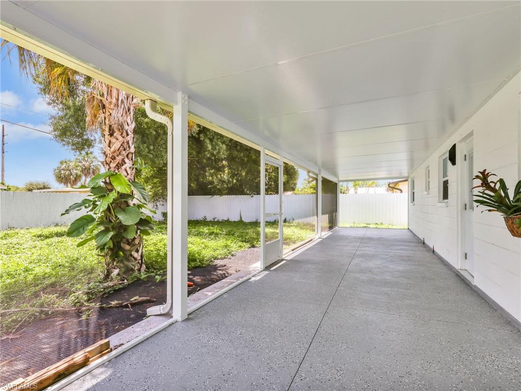 Expansive screened patio featuring a textured concrete floor, white shiplap exterior siding, and a solid white overhead roof