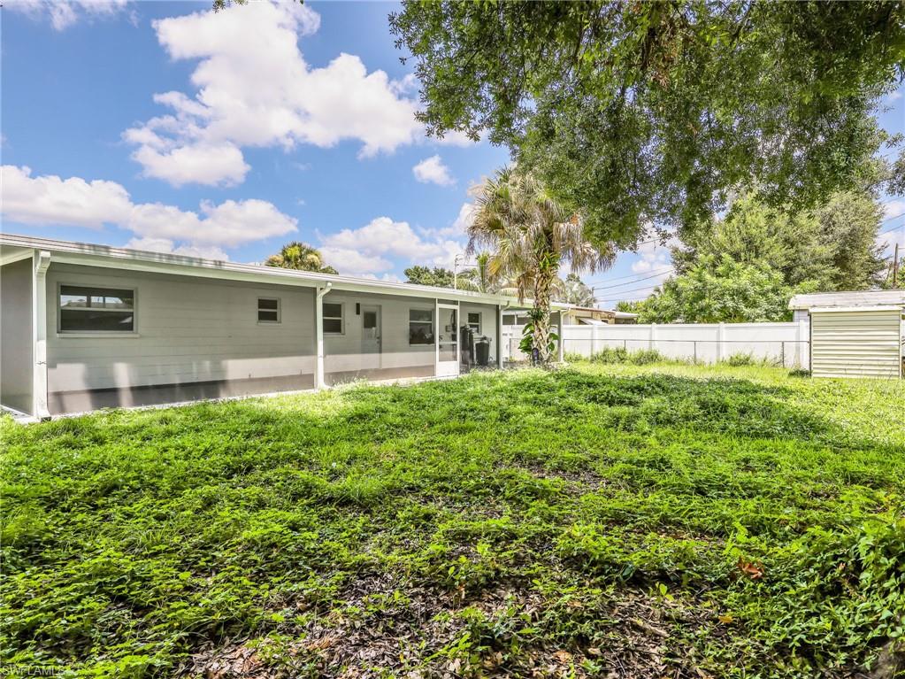 Expansive backyard featuring a covered patio, a storage shed, and a privacy fence
