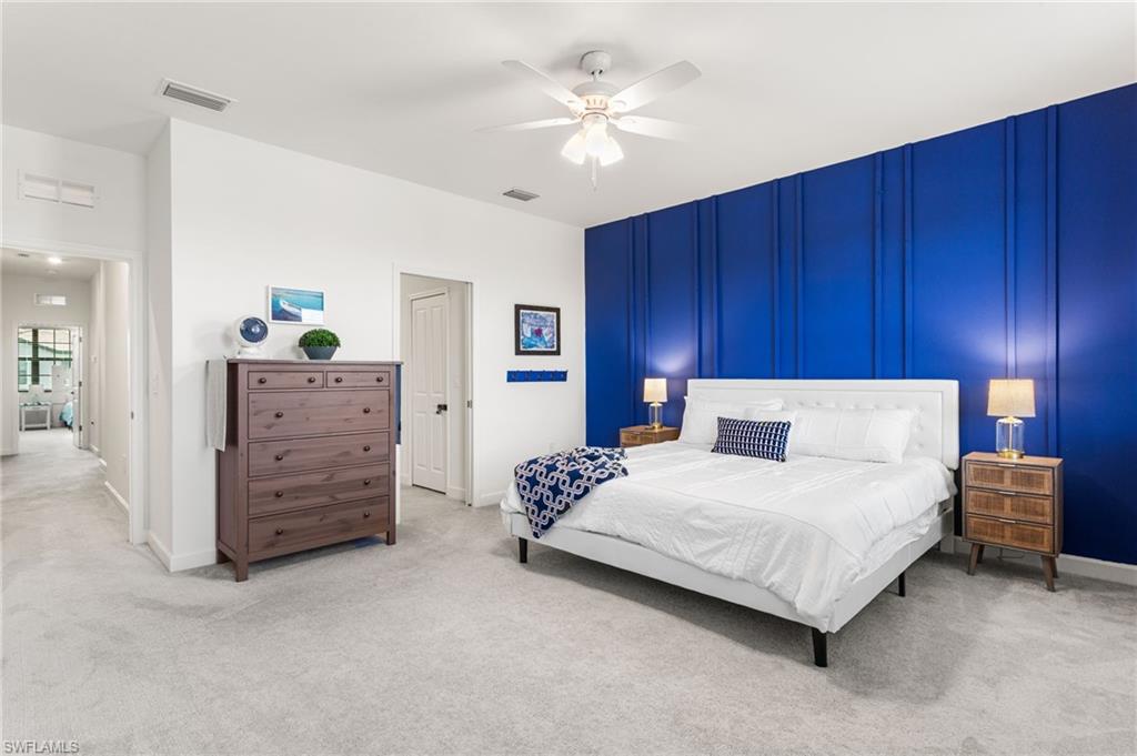 Spacious primary suite offering plenty of room to relax, highlighted by a striking designer accent wall and ceiling fan :)