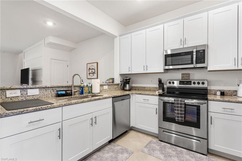 Bright, spacious kitchen featuring white shaker cabinetry, granite countertops, and stainless steel appliances