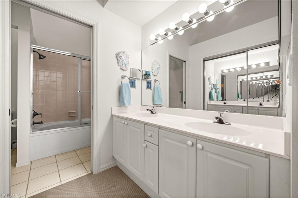 Primary bath with dual vanity and private tub/shower area.