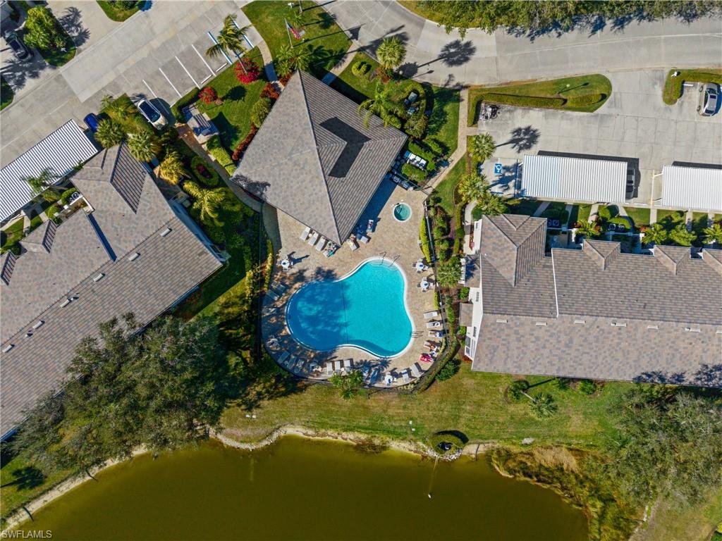 Community pool and spa surrounded by tropical landscaping.