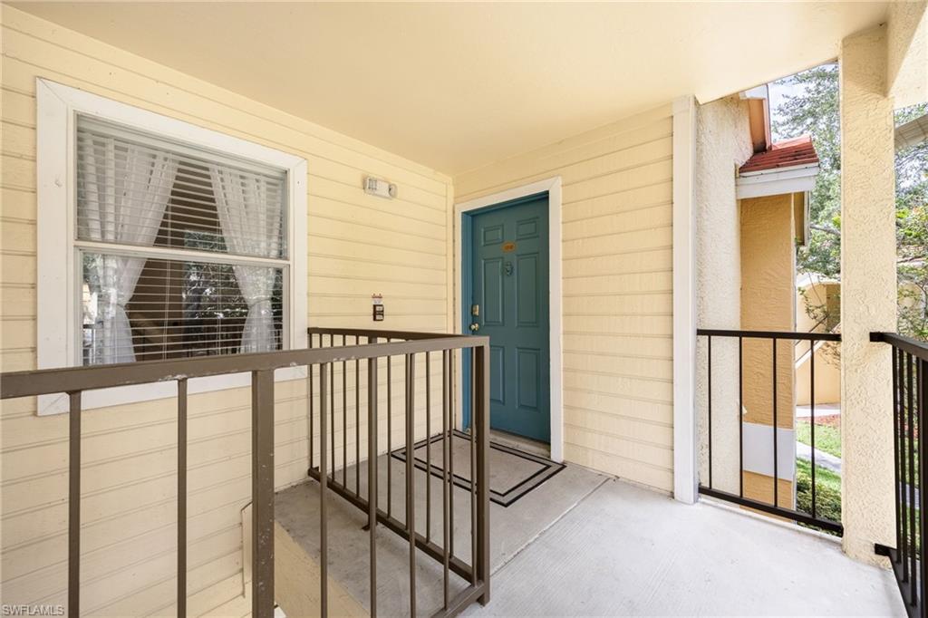 Entryway featuring a teal door, concrete flooring, horizontal siding, and a window with blinds